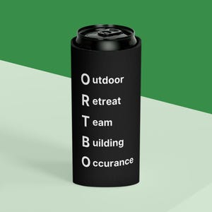 May include: Black can cooler with white text that reads "Outdoor Retreat Team Building Occurrence".