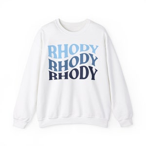 May include: White sweatshirt with a blue, light blue, and dark blue gradient print of the word "RHODY" repeated three times.
