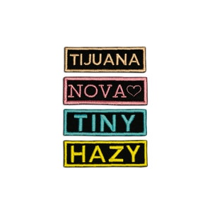 May include: Four embroidered patches with black backgrounds and colorful borders. The patches read "Tijuana", "Nova", "Tiny", and "Hazy".