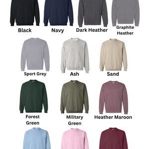 May include: A chart showing 12 different colors of crewneck sweatshirts. The colors are: black, navy, dark heather, graphite heather, sport grey, ash, sand, forest green, military green, heather maroon, light blue, light pink, and maroon.