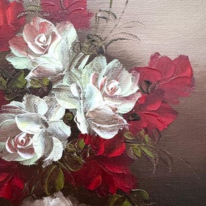 May include: A close-up of a still life painting featuring white and red roses in a vase. The roses are painted with thick brushstrokes, giving the painting a textured look.