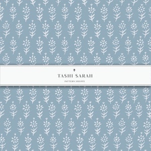 May include: A seamless pattern featuring a repeating design of white stylized flowers on a light blue background. The pattern is labeled "Tashi Sarah Pattern Shoppe".