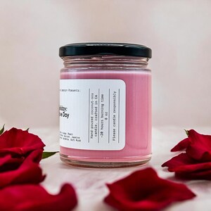 Pode incluir: Uma vela rosa num frasco de vidro com tampa preta. O r&oacute;tulo diz "Vela de soja e coco feita &agrave; m&atilde;o, fabricada na Calif&oacute;rnia - 20 horas de tempo de queima 8 oz Por favor, use a vela de forma respons&aacute;vel".