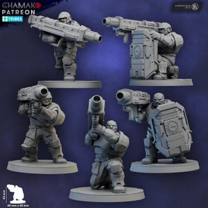 May include: A collection of gray miniature figurines of soldiers in combat poses, holding large futuristic weapons and shields. The figures are on individual bases, with the "Ghamak Patreon Tribes" logo visible in the upper left corner. The dimensions are 40 mm x 40 mm.