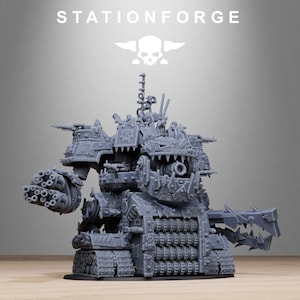 Puede incluir: Maqueta gris detallada de una máquina de guerra con múltiples torretas, cañones y una boca amenazante y dentada. El modelo presenta orugas de tanque y el texto "STATIONFORGE" en la parte superior. También es visible un logotipo de calavera y alas.