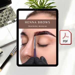 Op de afbeelding: Een digitale tablet met een trainingshandleiding voor henna wenkbrauwen. De omslag van de handleiding toont een close-up van een wenkbrauw van een persoon die met henna wordt geverfd. De tekst op de omslag luidt "HENNA BROWS TRAINING MANUAL".