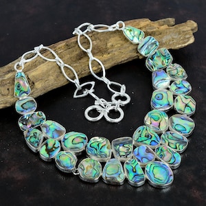 May include: A silver chain necklace with a multi-colored abalone shell pendant. The pendant is made up of several individual shell pieces, each with a unique iridescent pattern.