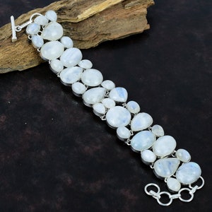 Könnte beinhalten: Ein silbernes Armband mit einer Reihe weißer Mondsteinperlen. Das Armband hat einen Karabinerverschluss und ist aus Sterlingsilber.