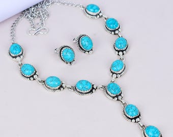 May include: A silver-toned jewelry set featuring a necklace and matching earrings. The necklace has a series of oval, turquoise-colored stones set in ornate silver settings. The earrings mirror the design with similar turquoise stones.