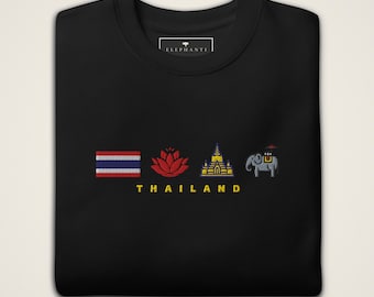 May include: A black crewneck sweatshirt featuring an embroidered design with the Thai flag, a red lotus flower, a golden temple, and a grey elephant. Below the icons, the word THAILAND is embroidered in yellow capital letters. The inner neck label reads ELEPHANTI.