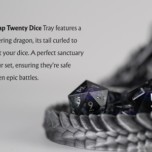 A close-up, artistic shot of the Nap Twenty Dice Tray showing galaxy-themed dice resting within the protective curve of a 3D-printed dragon's tail. Descriptive text on the left reads: "The Nap Twenty Dice Tray features a slumbering dragon, its tail curled to protect your dice. A perfect sanctuary for your set, ensuring they're safe between epic battles." The focus is sharp on the metallic scale texture and the shimmering dice.