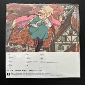 May include: A CD case featuring an animated illustration of two characters from a Japanese animated film. The artwork depicts a man and a woman on a rooftop with a cityscape in the background. The case includes Japanese text and track listings.
