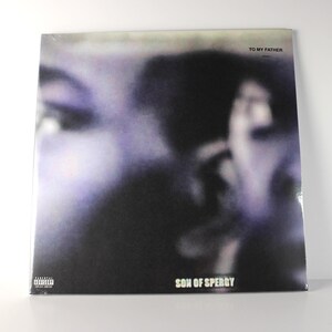 May include: A vinyl record album with a blurred image of a person in shades of purple and black. The text "TO MY FATHER" is at the top, and "SON OF SPERGY" is at the bottom. A parental advisory warning is in the lower left corner.