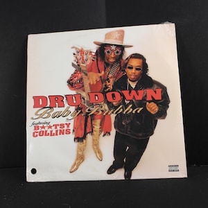 May include: Album cover for the music group Dru Down, featuring Baby Bubba and Bootsy Collins. The album cover has a white background with the group's name in red and gold lettering. The image features two men in flamboyant outfits.