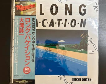 Può includere: Una copertina di un album in vinile bianco con il titolo "LONG VACATION" in testo nero. La copertina dell'album presenta una piscina con un cielo blu e palme. Il nome dell'artista, "EIICHI OHTAKI", è stampato in nero nella parte inferiore della copertina. L'album è un'edizione del 40° anniversario dell'album del musicista giapponese.