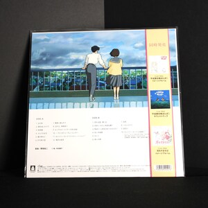 K&ouml;nnte beinhalten: Ein Vinyl-Schallplattenalbum mit einer farbenfrohen Illustration von zwei Personen auf einem Dach mit Blick auf eine Stadtlandschaft. Das Albumcover enth&auml;lt japanischen Text und Bilder anderer Alben. Das Album ist in Kunststoff versiegelt.