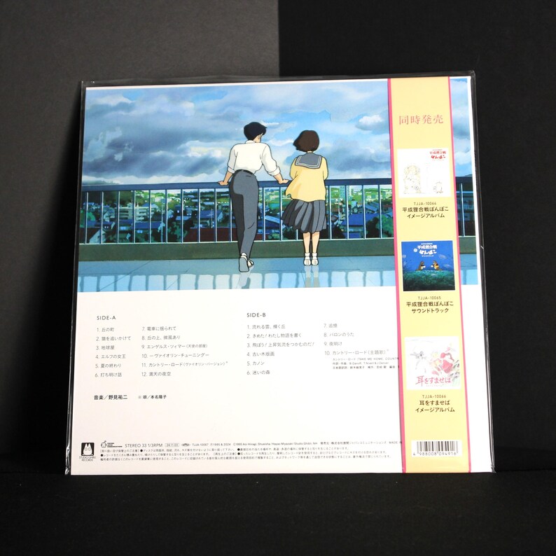 K&ouml;nnte beinhalten: Ein Vinyl-Schallplattenalbum mit einer farbenfrohen Illustration von zwei Personen auf einem Dach mit Blick auf eine Stadtlandschaft. Das Albumcover enth&auml;lt japanischen Text und Bilder anderer Alben. Das Album ist in Kunststoff versiegelt.