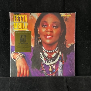 May include: A vinyl record album cover featuring Letta Mbulu. The album cover has a portrait of a woman wearing multiple necklaces and bracelets. The album title is "Letta Mbulu" and the album is titled "In The Music..."