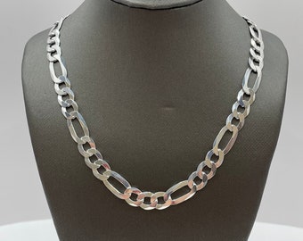 May include: A silver chain necklace with a figaro link pattern. The chain is displayed on a gray mannequin.