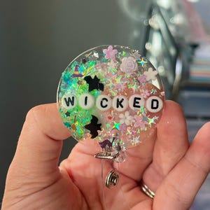 Carrete de insignia de resina brillante de Wicked the Musical: pinza de cocodrilo
