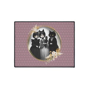 May include: A decorative mat featuring a whimsical illustration of three figures within a gold-colored oval frame. The figures include two doll-like characters and a black cat, all adorned in gothic-style attire. The background is a pink damask pattern.