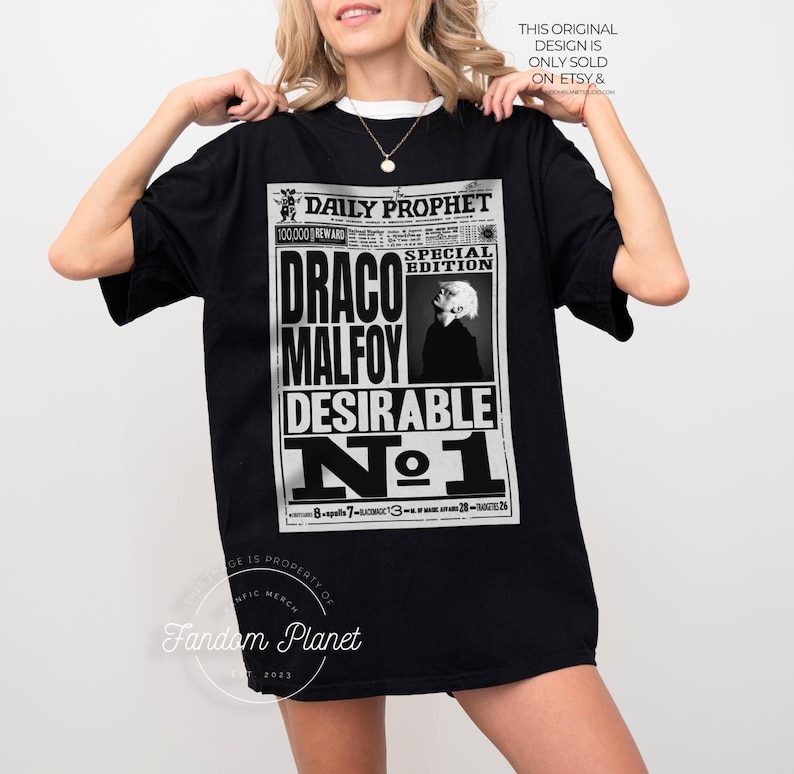 May include: Black t-shirt with a graphic print of a newspaper headline that reads "Daily Prophet Special Edition Draco Malfoy Desirable No. 1".