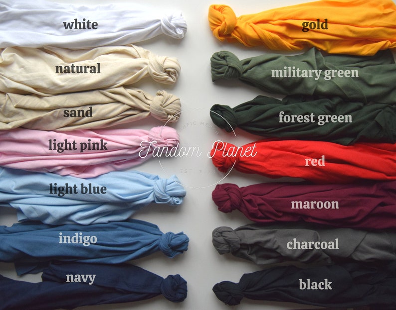 May include: A collection of 14 t-shirts in various colors, including white, natural, gold, military green, sand, forest green, light pink, red, light blue, maroon, indigo, charcoal, navy, and black. The t-shirts are folded and arranged in two rows, with the colors alternating.