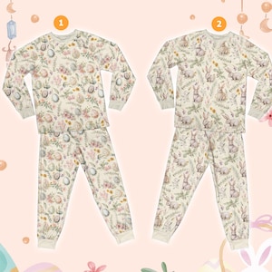 May include: Two-piece pyjama sets with a cream backdrop and an Easter-themed pattern. One set features eggs and floral designs, the other showcases bunnies and foliage. Both sets have long sleeves and matching trousers with ribbed cuffs.