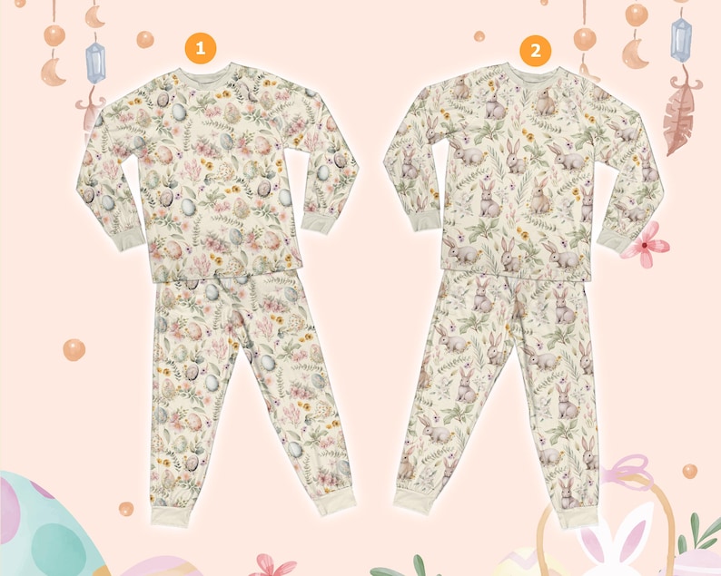 May include: Two-piece pyjama sets with a cream backdrop and an Easter-themed pattern. One set features eggs and floral designs, the other showcases bunnies and foliage. Both sets have long sleeves and matching trousers with ribbed cuffs.
