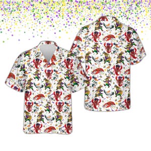 May include: White short-sleeve button-down shirt with a vibrant, all-over print. The design features cartoon crawfish, ducks, and figures in Mardi Gras attire. The shirt has a classic collar and a relaxed fit, perfect for casual wear.