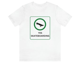 以下が含まれることがあります： 黒いスケートボードが描かれた緑色の円と「YES SKATEBOARDING」と書かれた緑色の看板がプリントされた白いTシャツ