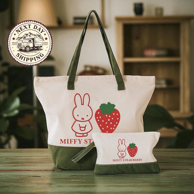 a large tote bag and a smaller pouch with a cartoon rabbit design, both with a strawberry motif, placed on a wooden surface.
