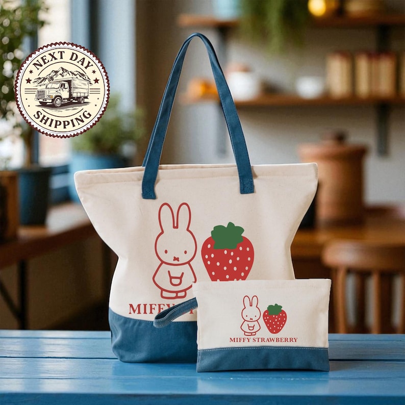 A large tote bag with a cartoon rabbit and a smaller bag with a strawberry design, both featuring the character Miffy Strawberry, are displayed on a blue surface.