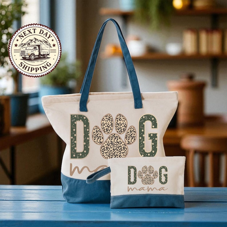 A large tote bag with a leopard print paw print design and the word "dog" printed on it, along with a smaller bag that says "dog mama" on it. The bags are placed on a blue surface, and there is a sign in the background that says "NEXT DAY SHIPPING".