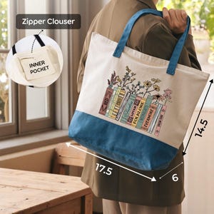 A person is holding a tote bag with a printed design of books and flowers on it. The bag has a zipper closure and a pocket on the front. The image also includes a diagram showing the dimensions of the bag, with the person's back visible.