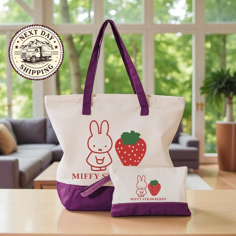 a large tote bag and a smaller pouch with a cartoon rabbit design, both with a strawberry motif, placed on a wooden surface.