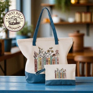 A large tote bag with a printed design of books and flowers, and a smaller bag with a similar design, both sitting on a blue surface.