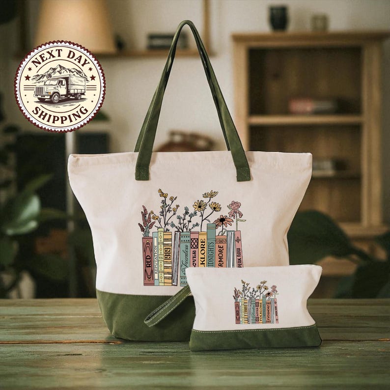 A large tote bag with a printed design of books and flowers on it, and a smaller pouch with a similar design, both sitting on a wooden surface.