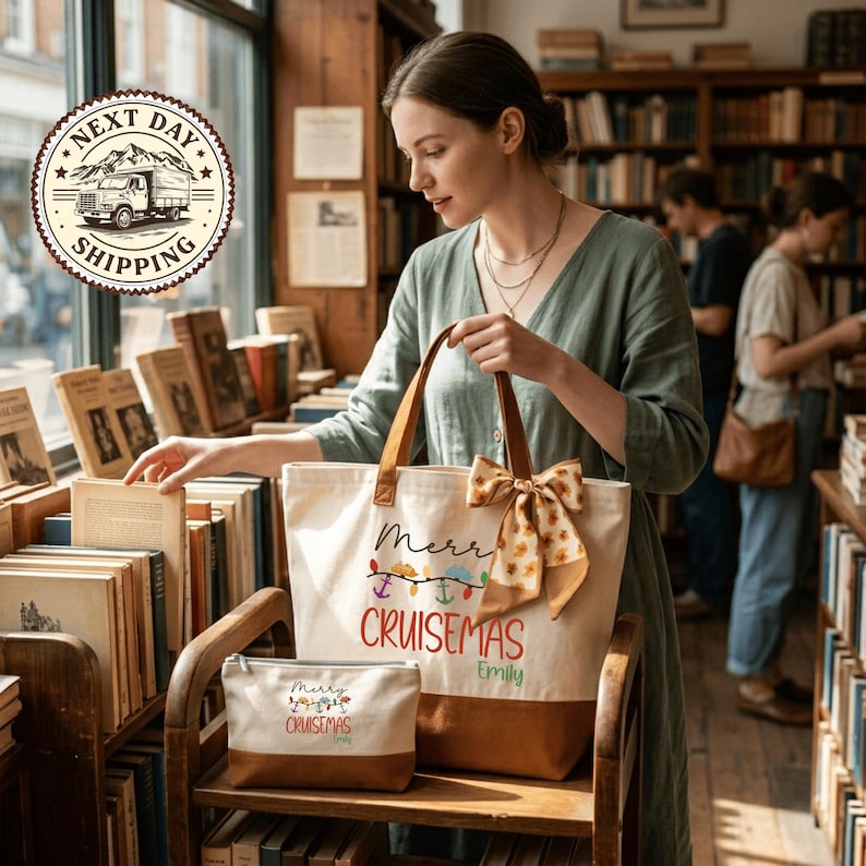 A woman is browsing through books in a bookstore, holding a tote bag with a Christmas-themed design.