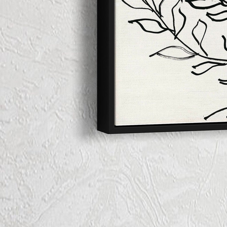 Pu&ograve; includere: Stampa in bianco e nero di arte lineare di un disegno floreale con foglie e steli. La stampa &egrave; incorniciata in una cornice nera.