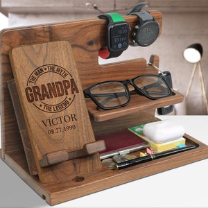 May include: A wooden desktop organizer with a phone stand, watch holder, glasses holder, and a compartment for other items. The organizer has a personalized inscription that reads "The Man, The Myth, Grandpa, The Legend, Victor 08.27.1990".
