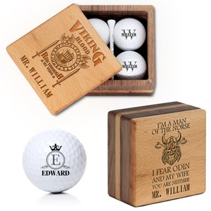 May include: Wooden golf ball gift set with personalized engraving. The set includes a wooden box with golf balls, tees, and a separate wooden box. The text on the box reads "VIKING BLOOD RUN THROUGH MY VEINS MR. WILLIAM". Another golf ball is also shown with the name "EDWARD".