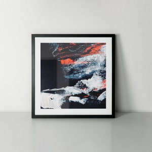 May include: Abstract art print in a black frame. The print features a colourful abstract design with shades of blue, white, and orange.