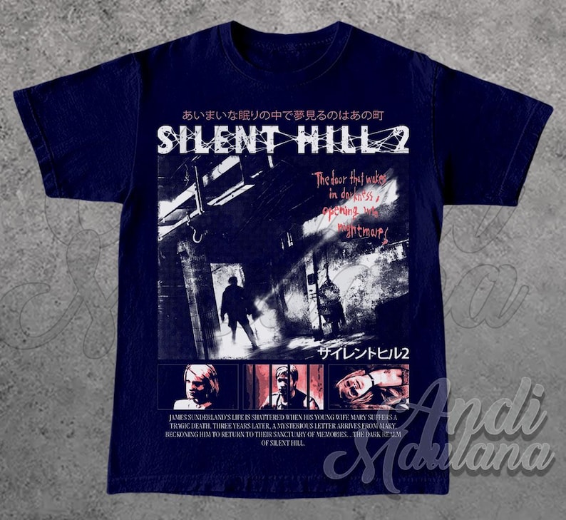 May include: Navy blue t-shirt featuring a graphic from the video game Silent Hill 2. The design includes Japanese text, the game's title, and a scene with figures in a dark hallway. The shirt also has text describing the game's plot.