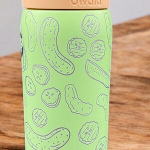 A green and yellow children's water bottle with a light lime design printed on it, sitting on a wooden surface.