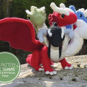 May include: A crochet pattern for a five-headed dragon, with a red, white, black, green, and blue color scheme. The pattern is available as a PDF download and uses UK terms.