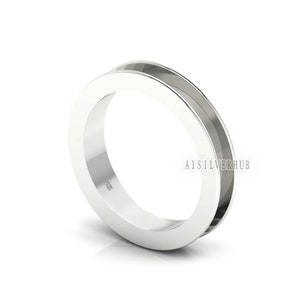 Könnte beinhalten: Ein silberner Ring mit einem breiten Band und einer Rille, die um die Innenseite des Bandes verläuft. Der Ring ist innen mit "925" gekennzeichnet.