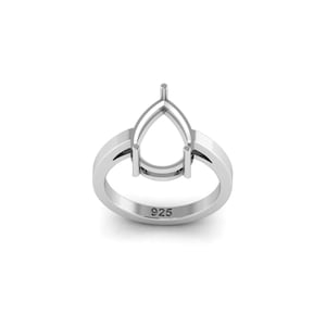 Puede incluir: Un engaste de anillo plateado con un centro en forma de pera. El anillo tiene un acabado liso y pulido y el número "925" está estampado en la banda. El engaste está diseñado para sostener una piedra preciosa.