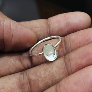 May include: A silver ring with an oval-shaped bezel setting. The ring is designed to hold a cabochon stone.
