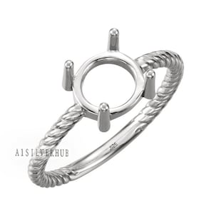 Könnte beinhalten: Ein silberner Ring mit einer runden, offenen Fassung für einen Edelstein. Der Ringarm ist gedreht und trägt den Stempel 925.